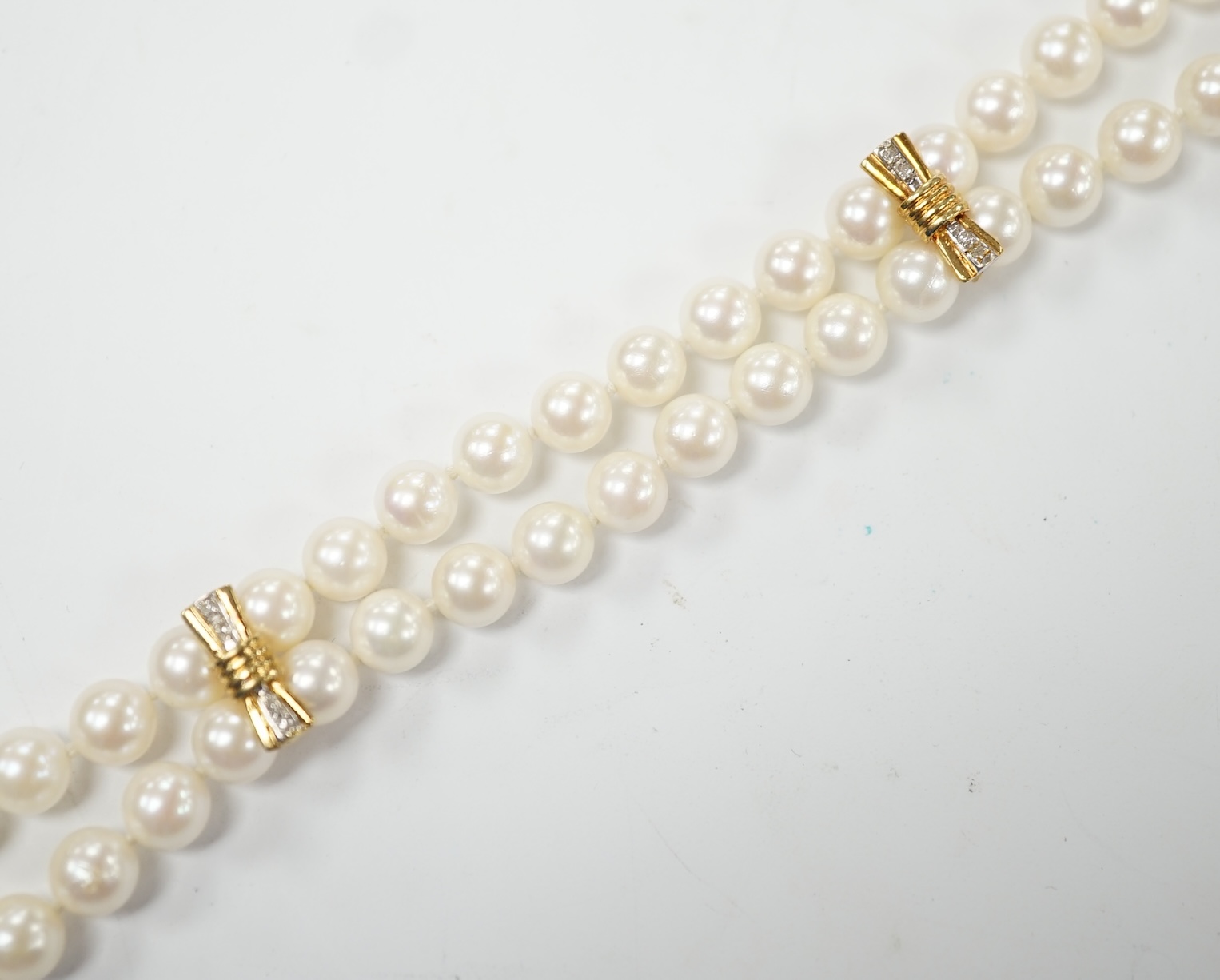 A double strand cultured pearl bracelet, with diamond chip set 14k clasp and spacers, 18cm. Condition - good